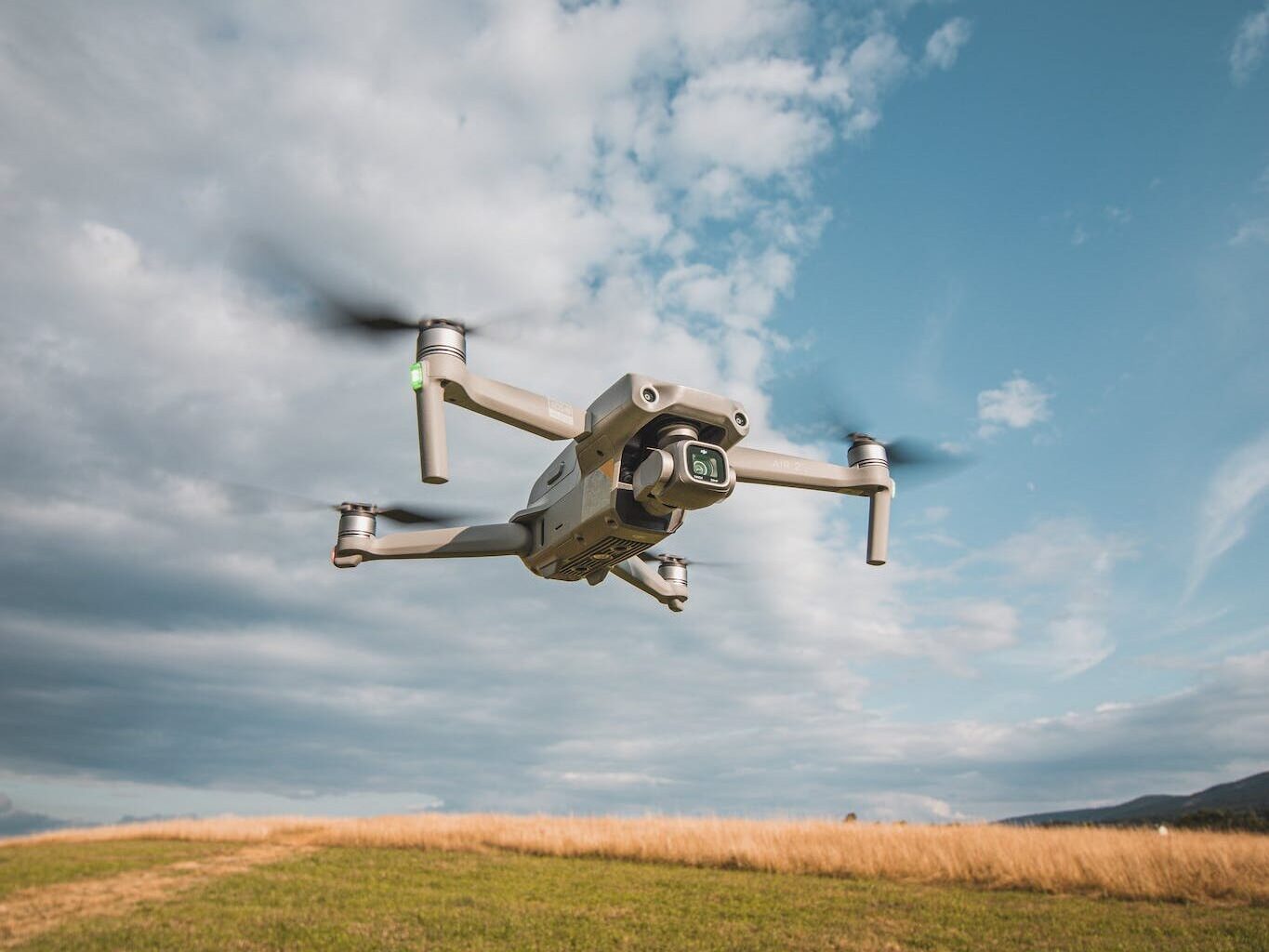 A small drone flying over a field